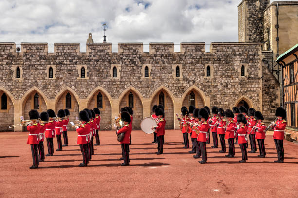 beefeaters and marching bands taking part in the changing of the guard in the lower ward of windsor castle - castle honor guard protection security guard imagens e fotografias de stock
