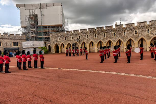 beefeaters e bandas de marcha que participam da troca da guarda na ala inferior do castelo de windsor - honor guard protection security guard tourist - fotografias e filmes do acervo