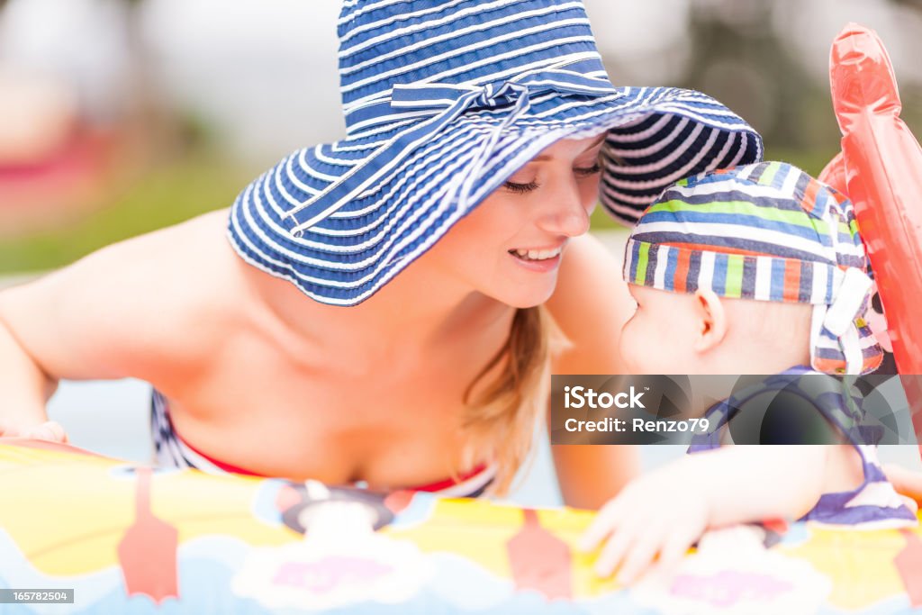 Niño feliz con mamá en swimmingpool - Foto de stock de 20 a 29 años libre de derechos