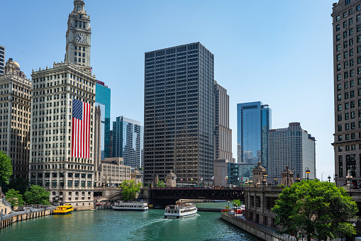 View of the Chicago, Illinois skyline with the Chicago River in the foreground an American flag on a building