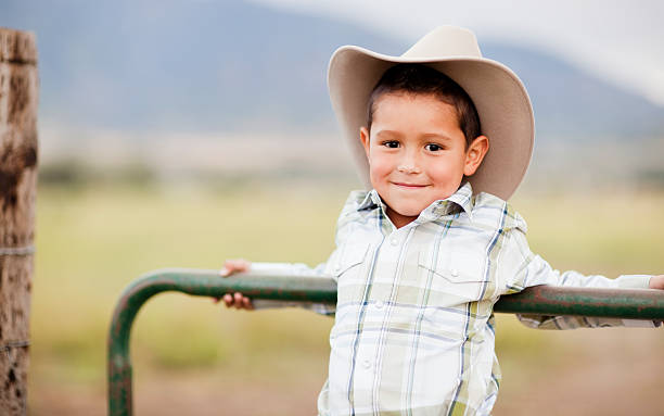 Little Cowboy Portrait of a young cowboy of Hispanic descent. texas cowboy stock pictures, royalty-free photos & images