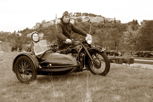 Road trip with a vintage motorcycle and sidecar. Desatured and toned image. Štanjel, Slovenia, Europe.