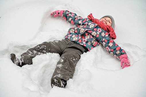 Happy childhood. Family time in winter, playing and laughing in the first snow.