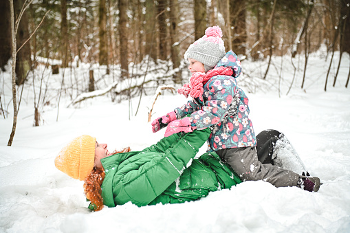 Single mom sledging with kids down the hill