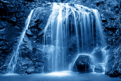 Fresh water waterfalls in lush green rainforest in New Zealand.