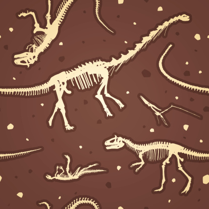 An illustration of seamless dinosaur fossils.  There are four full dinosaur skeletons visible.  One skeleton is only partially visible and there are three tails visible but the bodies they belong to cannot be seen.  The skeletons are in a light brown color that looks almost white.  All around the background there are specks in the same color as the dinosaur skeletons, and some that are in dark brown.  Two of the skeletons are upright and two are lying on their backs.  The illustration is set in a dark brown background.