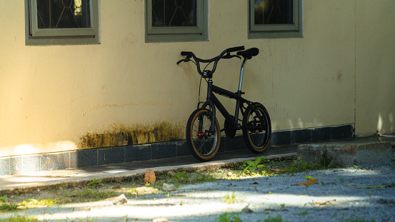 a bicycle parked under a building window