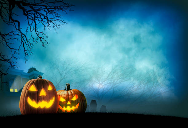 Jack O'Lanterns On Halloween Night Two illuminated jack o'lanterns sit in front of a haunted house in the distance. Bare trees in the fog and mist frame the haunted house. haunted house stock pictures, royalty-free photos & images