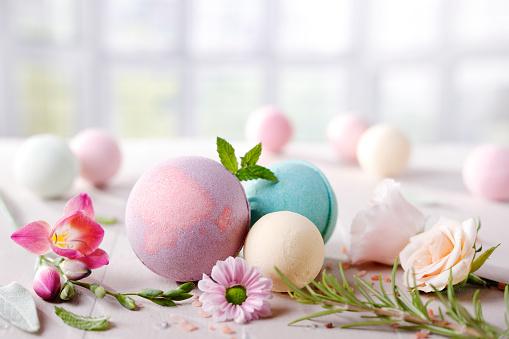 Different colorful  bath bombs and flowers with  copy space