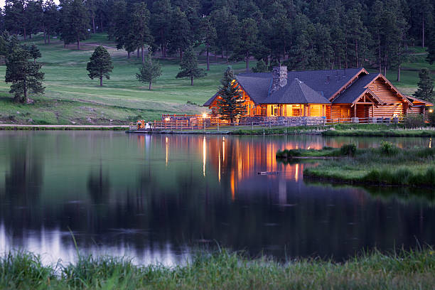 Mountain Lodge Reflecting in Lake at Dusk stock photo