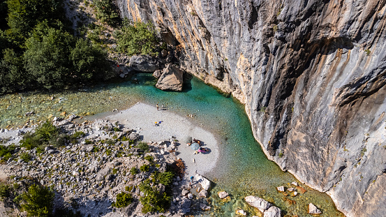 Aerial drone view of small beach on turquoise river of Valbona valley, Theth national park, Albanian Alps, Albania