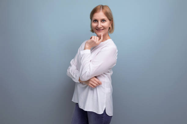istock positive blond middle aged woman in white blouse on studio background 1658047341