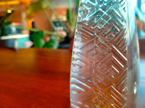 The bottle is placed on a table in a cafe for the dishes served