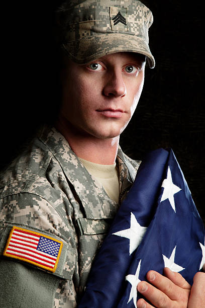 istock American Soldier Series: Young Sergeant Holding a Folded Flag 165822234