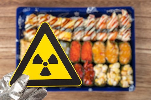 nuclear radiation warning sign above blurred sushi horizontal composition