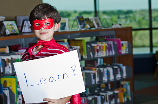 Little superhero with learn sign