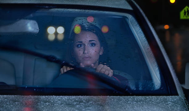 Night driving in Rain Storm Young woman driving at night through a heavy rain storm. windshield wiper stock pictures, royalty-free photos & images