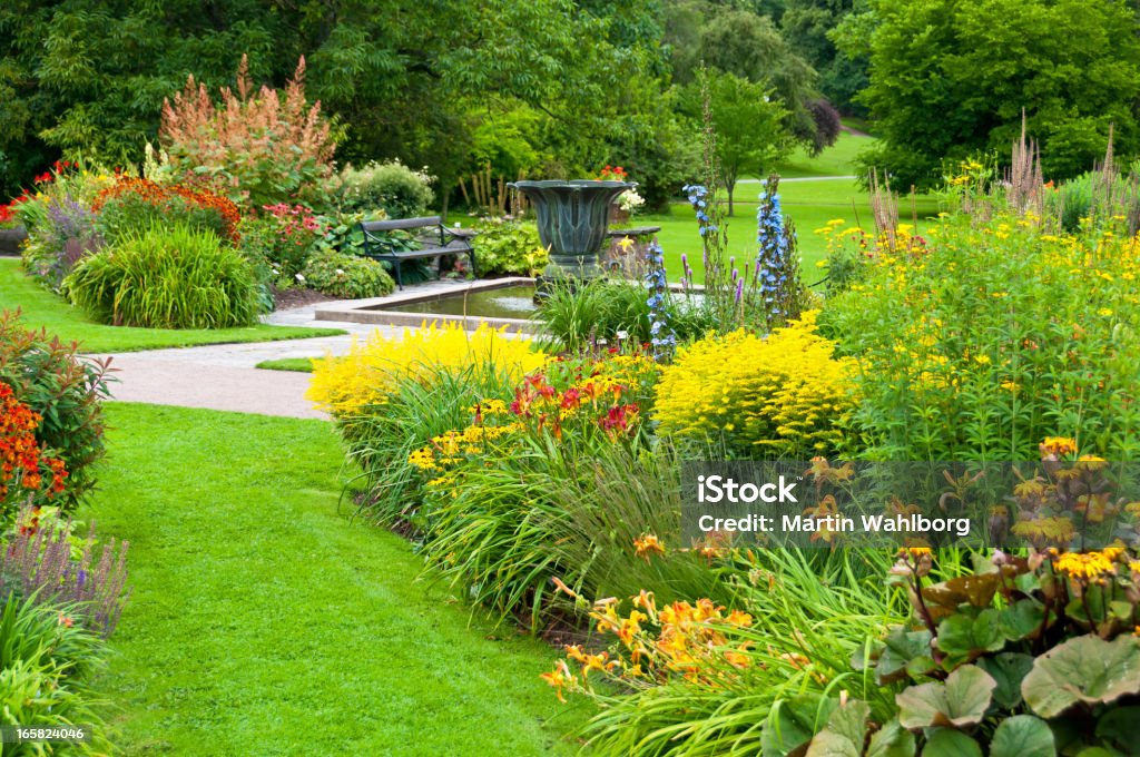 Flowerbeds e prato nel bellissimo parco - Foto stock royalty-free di Giardino domestico