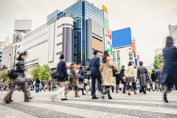 Crowded Shibuya Crossing Tokyo Japan People walking over famous zebra crossing at Shibuya Crossing in Downtown Tokyo. Long exposure. Motion Blurred People. Tokyo, Japan. tokyo crowds on the famous shibuya crossing japan stock pictures, royalty-free photos & images