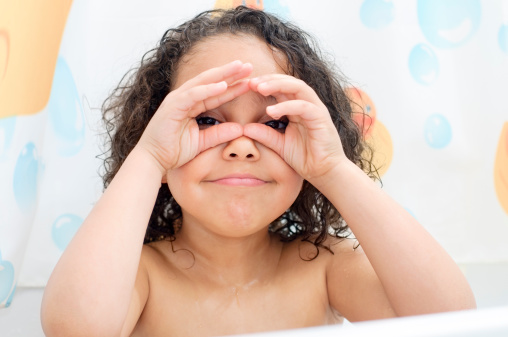 Royaly free stock photo of 5 years old girl making funny face. She is pretending to look through binoculars.