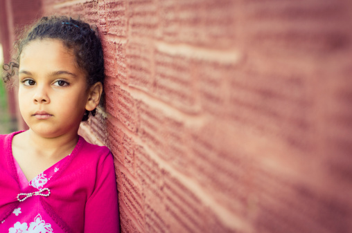 Royalty free stock photo of little girl (5-6) looking pensive. Shot with shallow depth of field.