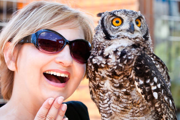 Lady and a barn owl looking upwards, surprised. Focus on the owl.