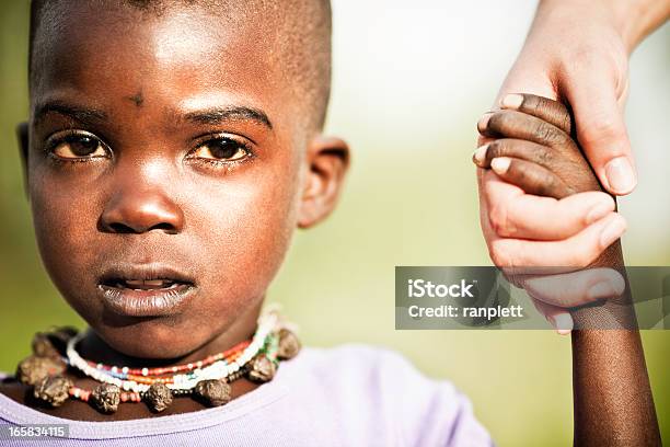 Foto de Jovem Africano Garoto Receber Uma Ajuda e mais fotos de stock de Tribo Hazda - Tribo Hazda, Ajuda Humanitária, Criança