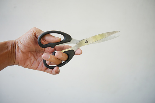 Businessman holding a pair of scissors on white background