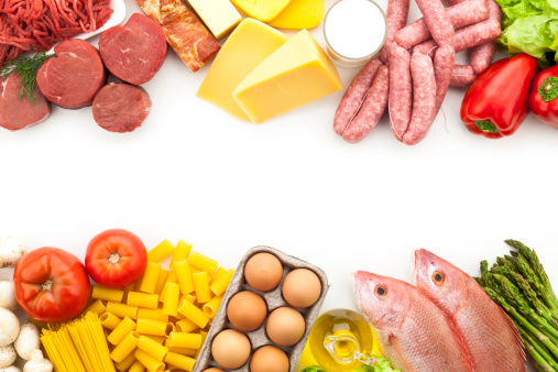 Assorted border of different types of food including meat, dairy products, sausages, some vegetables, pasta, eggs, cooking oil and fish on white backdrop. The food is arranged in two stripes at the top and bottom of the frame leaving a plenty copy space at the center of the frame. Colors are very vibrant and saturated. Shot directly from above with DSRL Canon EOS 5D Mk II