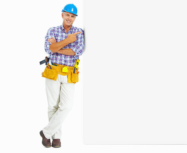 comprimento total de carpinteiro com cinto de ferramentas apontar em texto - manual worker full length isolated on white standing imagens e fotografias de stock