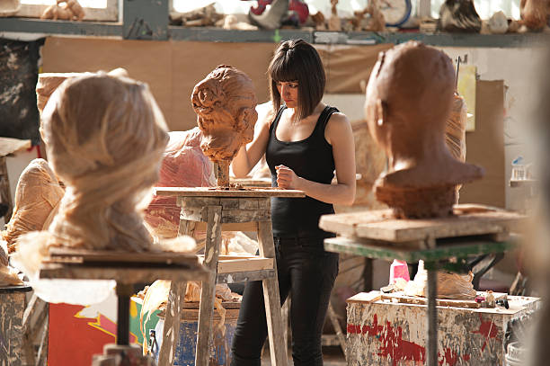 Artist's Workshop The Artist Series: Beautiful young sculptor creates a clay sculpture sculptor photos stock pictures, royalty-free photos & images
