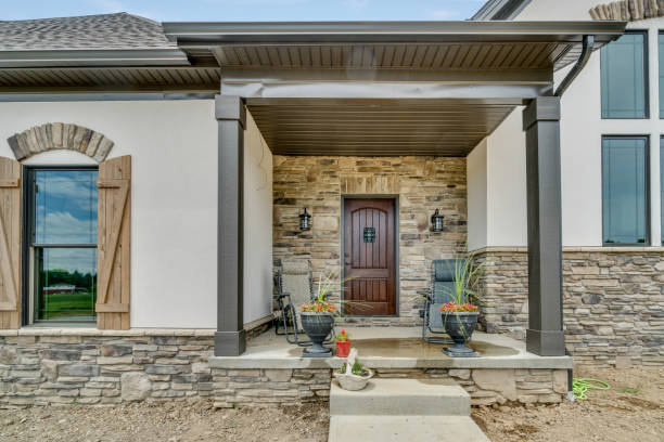 istock Front porch with potted plants and a stone facade 1658376494