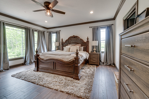 Wood flooring with rug and long drapes for the windows