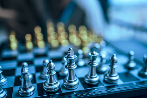 An Asian boy is thinking about how to play chess
