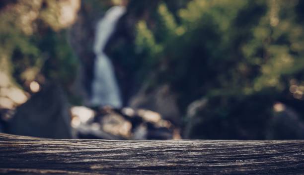 istock Dark wooden surface on the background of waterfall 1658397892