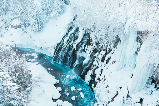 Shirahige Waterfall with Snow in winter, Biei river flow into Blue Pond. landmark and popular for attractions in Hokkaido, Japan. Travel and Vacation concept