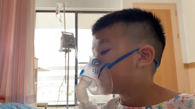 A child is being treated with an asthma inhaler.