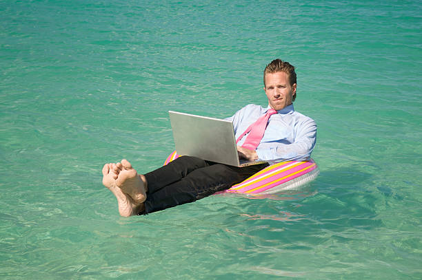 istock Businessman Floats with Laptop in Crystal Blue Waters 165843327