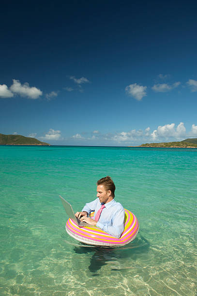 istock Businessman Floats in Tropical Waters with Laptop 165843331