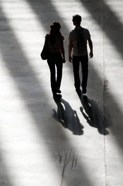 istock Shadowy Couple Walks Together in Slanted Sunlight 165843384