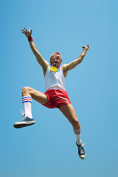 istock Gold Medal Nerd Athlete Jumps in Blue Sky 165843614