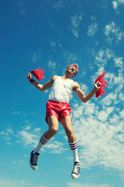 istock Nerd Athlete Cheerleader Jumps with Pom-Poms 165843627