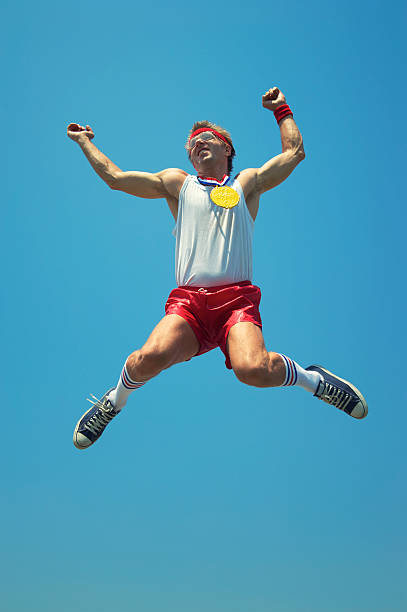 istock Gold Medal Nerd Athlete Jumps in Blue Sky 165843700