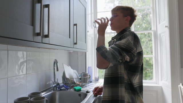 Teenage boy drinking tap water