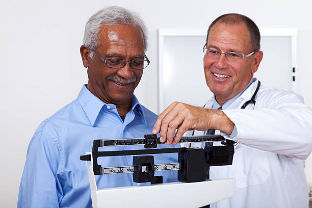 gewicht überprüfen - dieting weight scale doctor patient stock-fotos und bilder