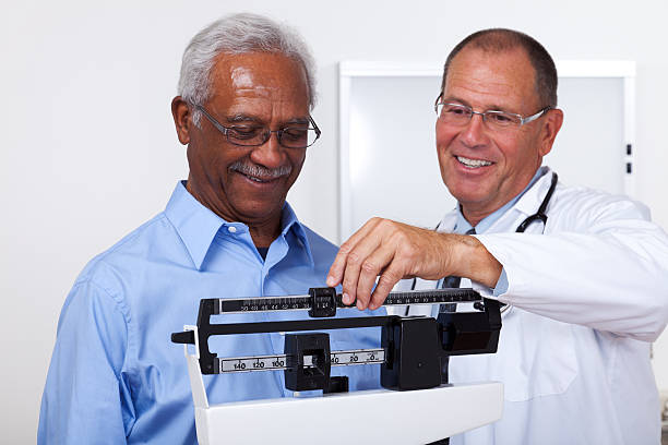 Weight Check XXXL.  Doctor checking weight of patient. gchutka stock pictures, royalty-free photos & images