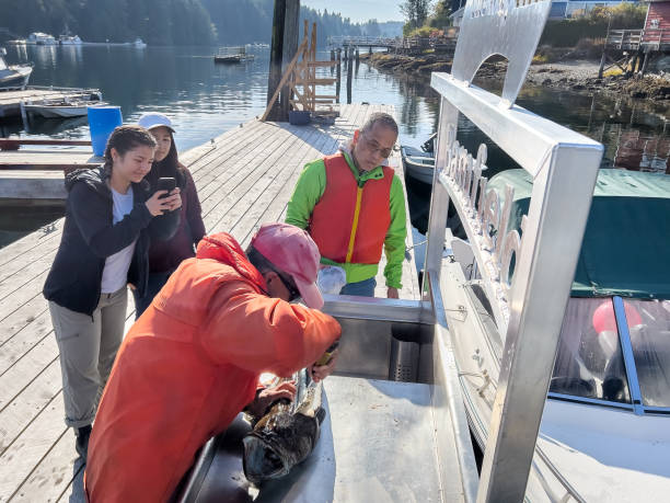 istock Senior Asian Man Teaching Extended Family How to Clean Fish 1658489222