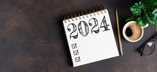 istock New year resolutions 2024 on desk. 2024 goals list with notebook, coffee cup, plant on table. Resolutions, plan, goals, action, checklist, idea concept. New Year 2024 resolutions 1658520101