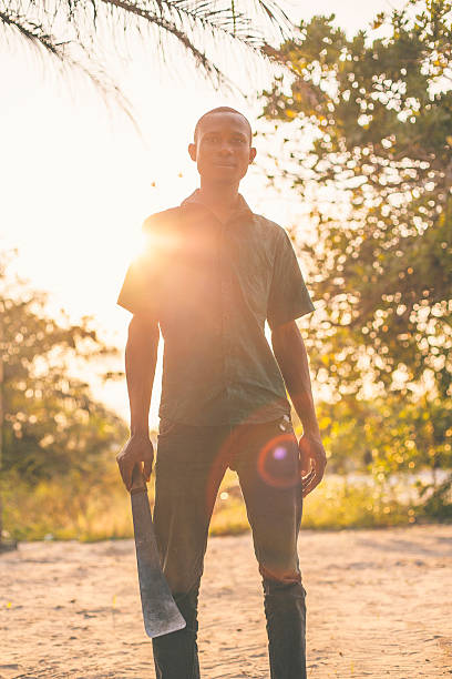 junge afrikanische mann hält machete. - nigerian culture men africa african culture stock-fotos und bilder
