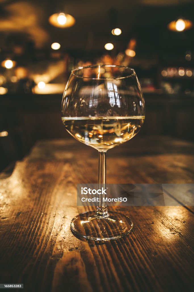 Glass of Wine, Restaurant in Tuscany Glass of wine on a wooden table, indoor. Alcohol - Drink Stock Photo